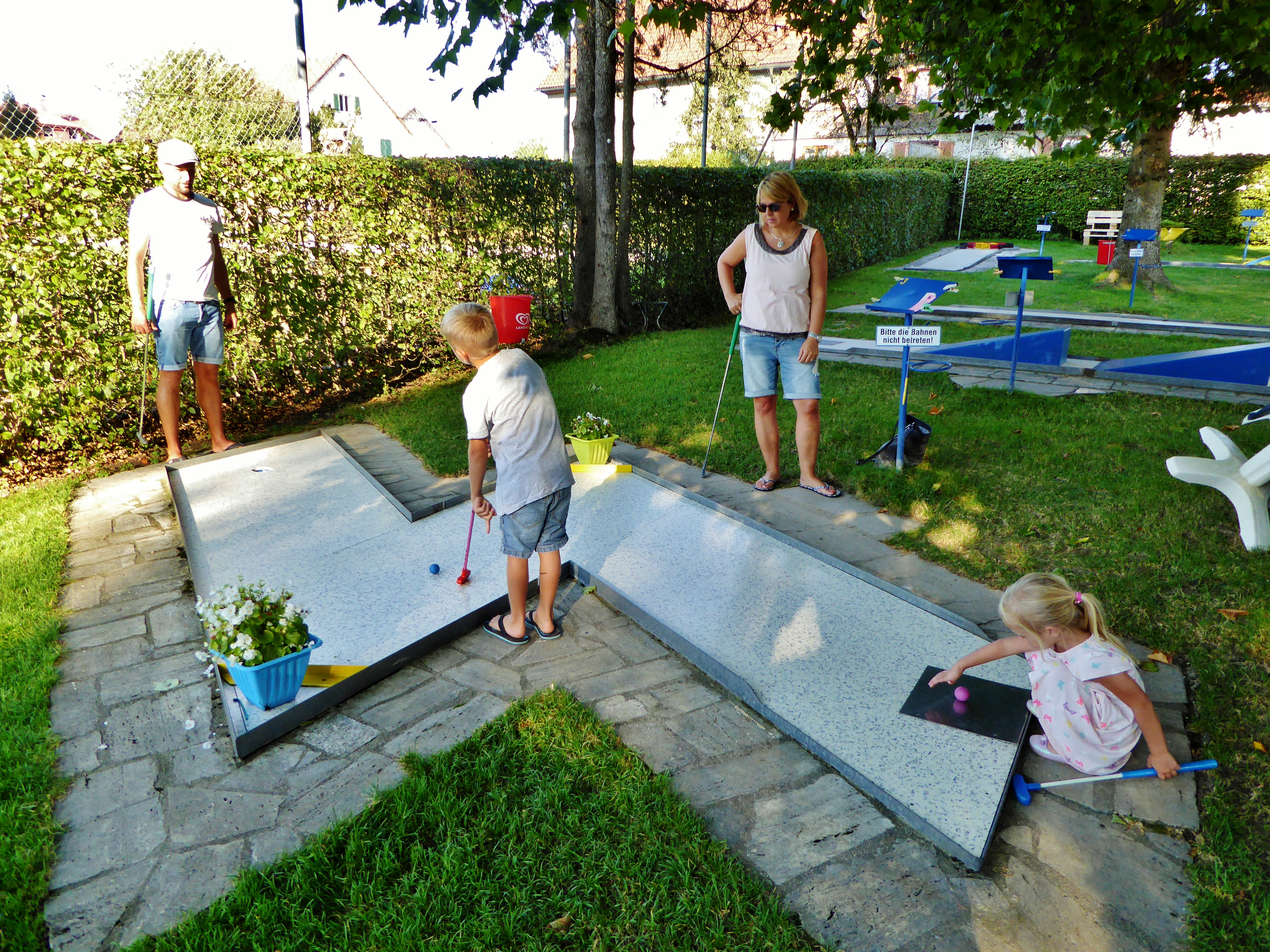  Familien spielt auf einer Minigolfbahn - das Bild wird mit Klick vergrößert 