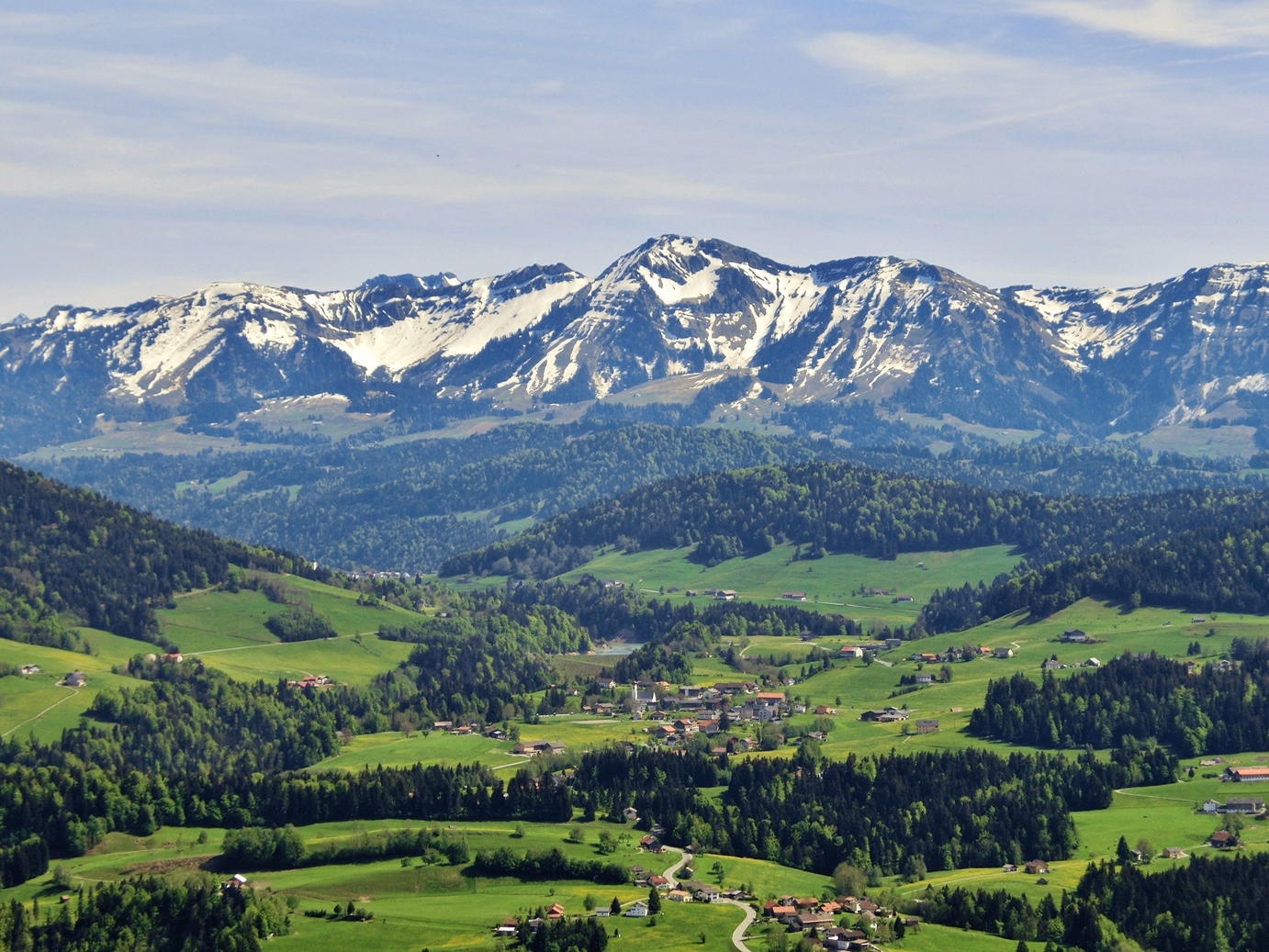  Blick in den Bregenzer Wald im Vordergrund und im Hintergrund schneebedeckte Berge - das Bild wird mit Klick vergrößert 