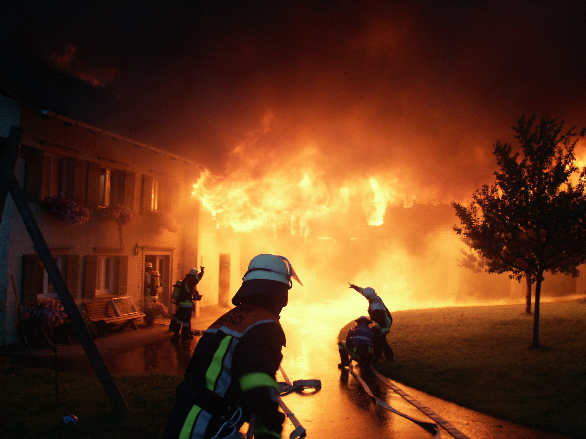  Bei Nacht löschen Feuerwehrmänner ein brennendes Haus - das Bild wird mit Klick vergrößert 