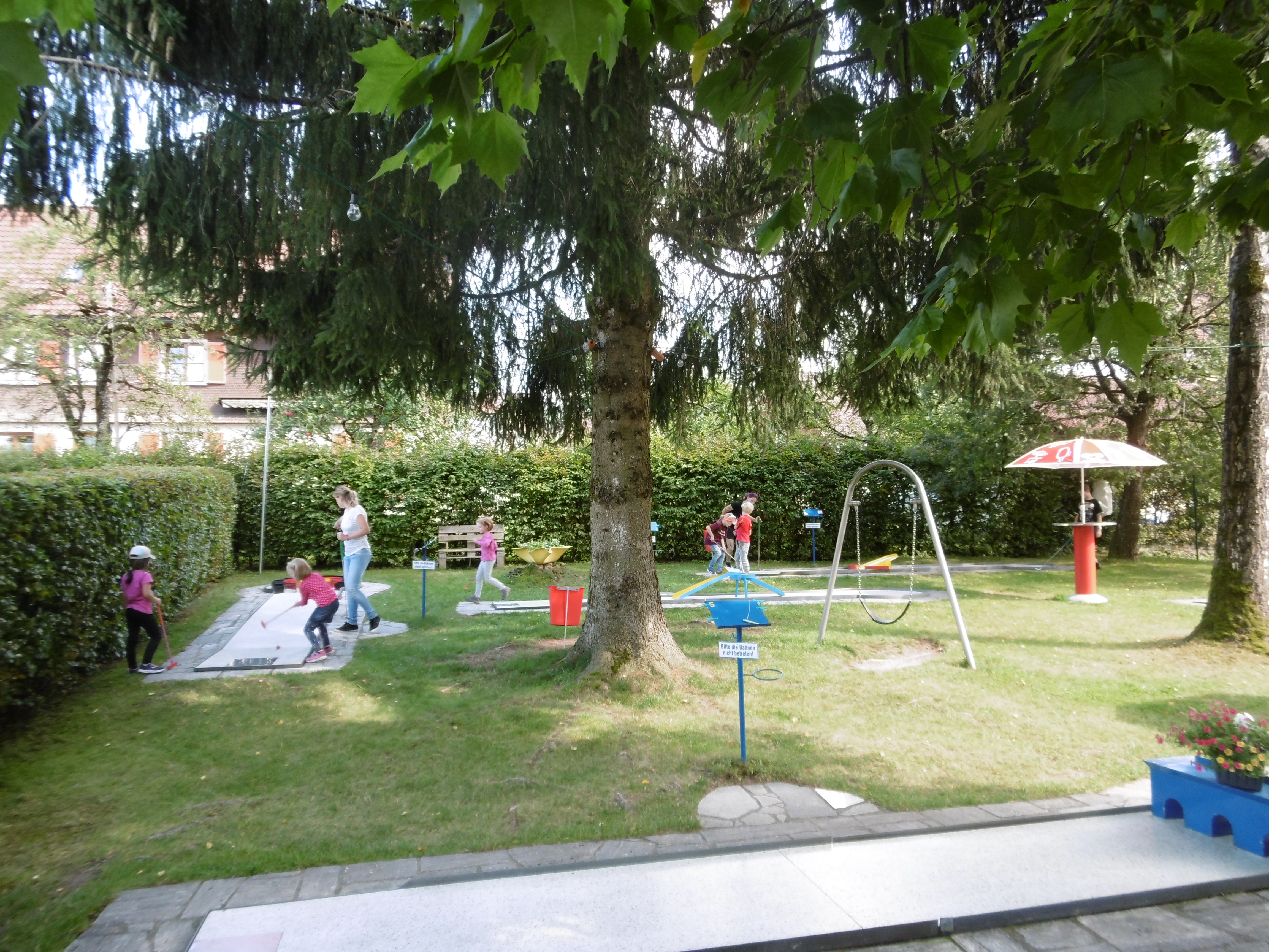  Kinder spielen an unterschiedlichen Stationen auf einer Wiese - das Bild wird mit Klick vergrößert 